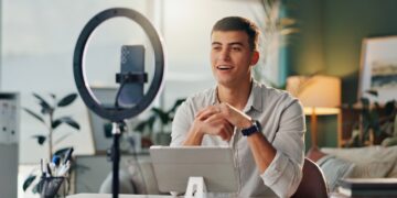 Man talking to phone in front of ring light