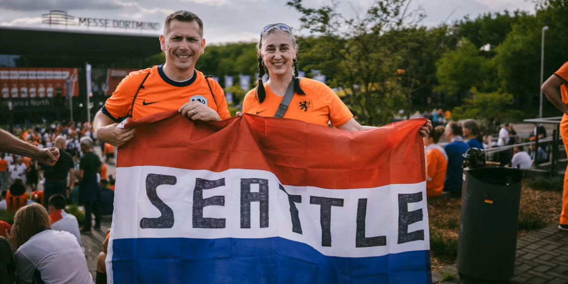 Netherlands fans at the World Cup holding a seattle flag